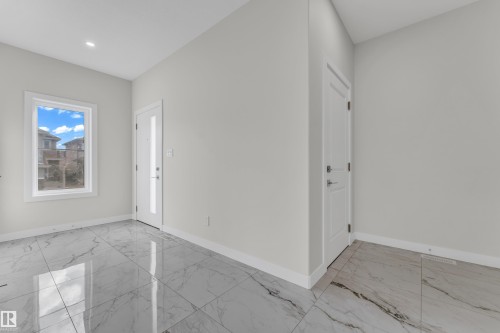 Foyer featuring large format marble-look tile flooring, white baseboards, and neutral wall paint - 12603 44 Street, Edmonton, AB - Indoor Photo Showing Other Room