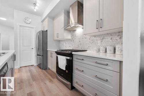Contemporary kitchen featuring light wood-finish flooring and two-tone cabinetry - 3623 6 Street, Edmonton, AB - Indoor Photo Showing Kitchen With Upgraded Kitchen