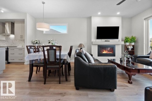 Open-concept living space featuring wood-finish flooring, a modern fireplace, and recessed lighting - 3623 6 Street, Edmonton, AB - Indoor With Fireplace