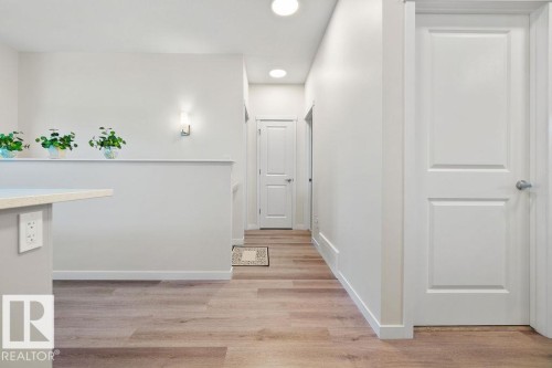 Interior hallway with light wood-finish flooring, white walls, and recessed ceiling lights - 3623 6 Street, Edmonton, AB - Indoor Photo Showing Other Room