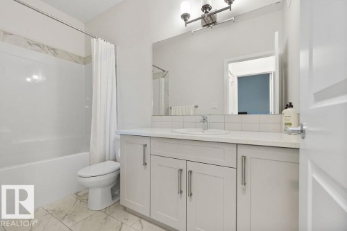 Contemporary bathroom featuring a single vanity with light grey cabinetry, a white countertop, and an undermount sink - 3623 6 Street, Edmonton, AB - Indoor Photo Showing Bathroom