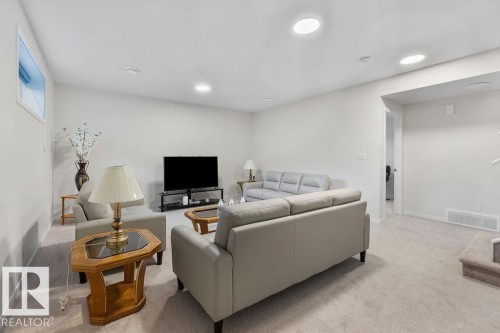 Carpeted living area featuring recessed lighting, light-toned walls, and a visible doorway - 3623 6 Street, Edmonton, AB - Indoor