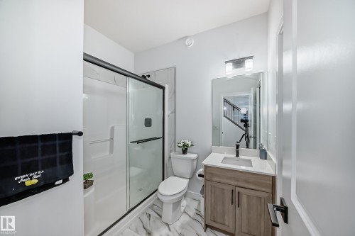 Bathroom featuring a vanity with a light wood-finish cabinet, a single-basin sink, and a framed mirror - 3247 Chernowski Way, Edmonton, AB - Indoor Photo Showing Bathroom