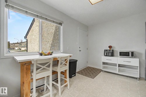 Bright room featuring a large window, light-toned walls, and geometric pattern flooring - 17305 60 Ave, Edmonton, AB 