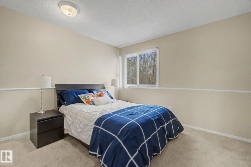 Room featuring neutral-toned walls, a white chair rail, and carpeting - 17305 60 Ave, Edmonton, AB 