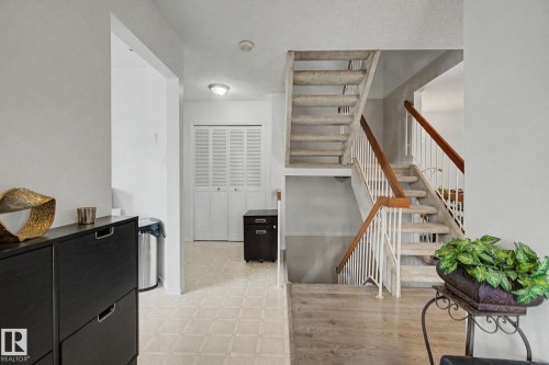 Split-level staircase with white railing and wood-finish handrails - 17305 60 Ave, Edmonton, AB 
