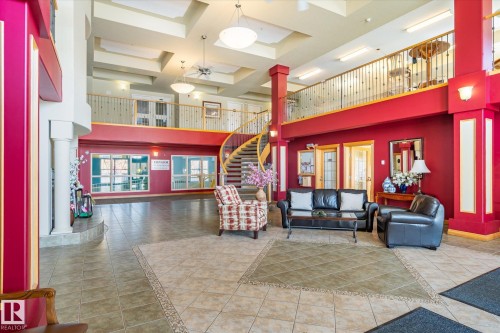 Spacious lobby with high ceilings, an elegant spiral staircase, and tile flooring - 104 612 111 Street Sw, Edmonton, AB - Indoor Photo Showing Other Room