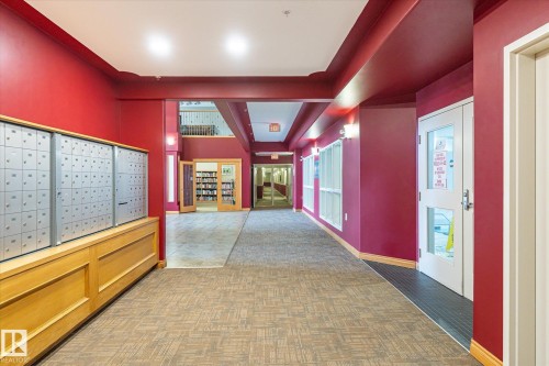 This area features carpeting, overhead lighting, and wall-mounted light fixtures - 104 612 111 Street Sw, Edmonton, AB - Indoor Photo Showing Other Room