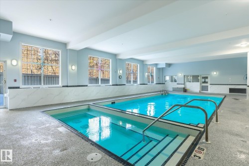 Indoor pool area featuring two distinct pools, large windows providing natural light, and tiled walls - 104 612 111 Street Sw, Edmonton, AB - Indoor Photo Showing Other Room With In Ground Pool
