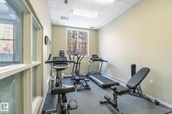 The fitness area features a selection of exercise equipment, a window with natural light, and overhead lighting - 