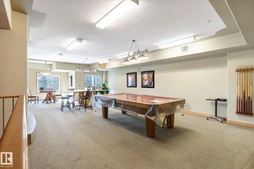 Spacious recreation area featuring a pool table, wall-mounted cue rack, and ample lighting - 104 612 111 Street Sw, Edmonton, AB - Indoor Photo Showing Other Room