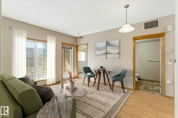 Living area featuring wood-finish flooring, a glass-paneled patio door, and a large window - 