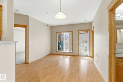 Living area featuring hardwood flooring, light-colored walls, and a window with a view to the outdoors - 