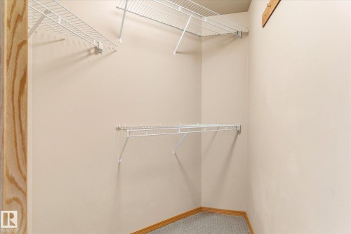 This closet features built-in wire shelving and a neutral color palette - 104 612 111 Street Sw, Edmonton, AB - Indoor With Storage