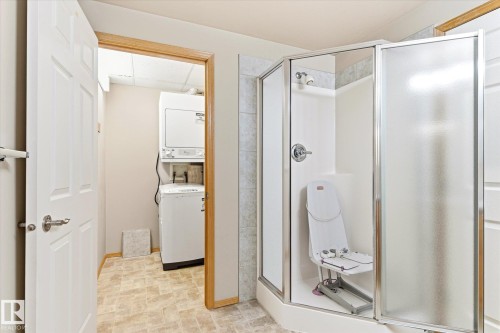 The property includes a shower with a clear glass enclosure and a separate area with a washer and dryer - 104 612 111 Street Sw, Edmonton, AB - Indoor Photo Showing Bathroom