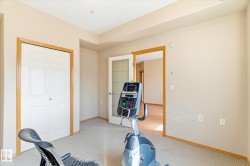 Versatile room featuring light-colored walls, neutral carpeting, and a white bi-fold closet with wood trim - 