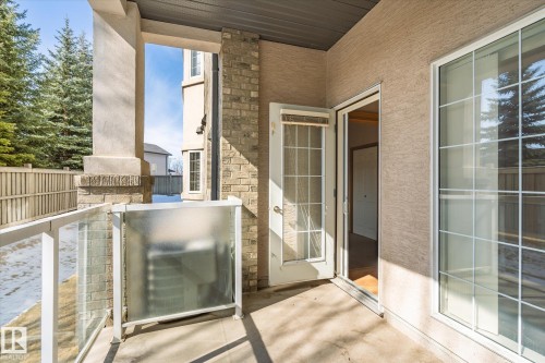 The property features a patio with a glass railing and a privacy screen - 104 612 111 Street Sw, Edmonton, AB - Outdoor With Exterior