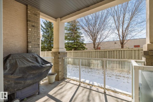 This property features an outdoor patio area with a covered ceiling, brick pillars, and a glass railing - 104 612 111 Street Sw, Edmonton, AB - Outdoor With Deck Patio Veranda With Exterior