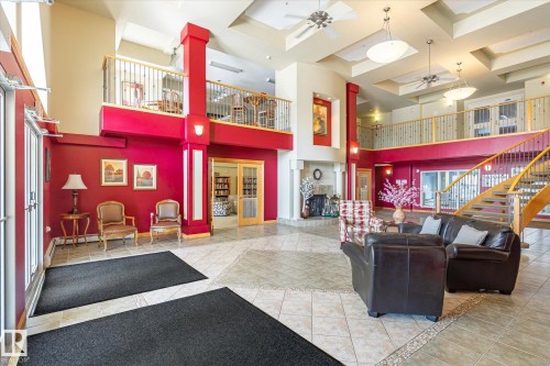Expansive common area featuring a two-story layout, a grand staircase, and a fireplace - 104 612 111 Street Sw, Edmonton, AB - Indoor Photo Showing Other Room