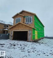 Two-story residential structure under construction featuring a prominent front-facing garage - 