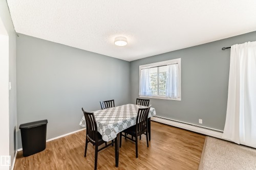 Dining area featuring wood-finish flooring and light gray walls - 423 5125 Riverbend Road, Edmonton, AB - Indoor Photo Showing Dining Room