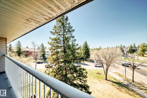 Balcony with white metal railing and a perforated ceiling panel, offering expansive neighborhood views - 423 5125 Riverbend Road, Edmonton, AB - Outdoor With Balcony