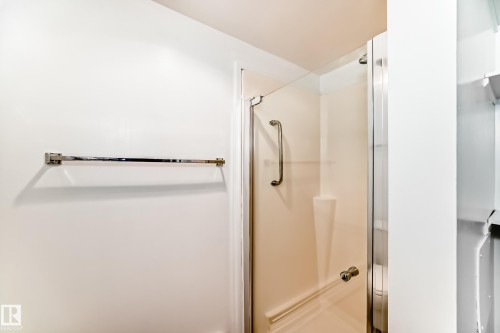 Glass-enclosed shower with a brushed chrome towel bar - 423 5125 Riverbend Road, Edmonton, AB - Indoor