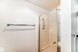 Glass-enclosed shower with a brushed chrome towel bar - 