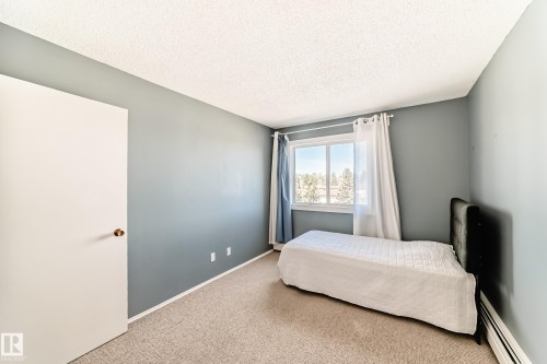 Room featuring neutral-toned carpet flooring and light blue painted walls - 423 5125 Riverbend Road, Edmonton, AB - Indoor Photo Showing Bedroom