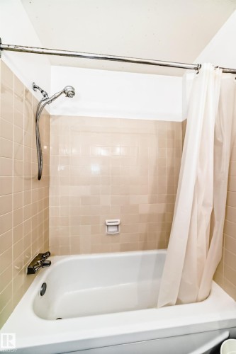 White porcelain bathtub with chrome fixtures and a handheld showerhead - 423 5125 Riverbend Road, Edmonton, AB - Indoor Photo Showing Bathroom