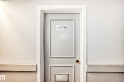 Laundry room entrance with a paneled door, brass hardware, and white trim - 