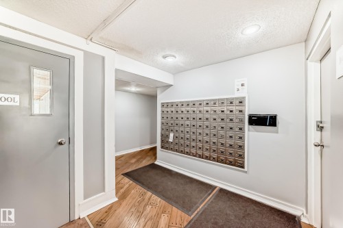 Common area featuring a wall-mounted mailbox system with individual compartments, recessed lighting, and wood-finish flooring - 423 5125 Riverbend Road, Edmonton, AB - Indoor Photo Showing Other Room