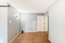 Interior space featuring wood-finish flooring, light gray walls, and white trim - 423 5125 Riverbend Road, Edmonton, AB  - Indoor Photo Showing Other Room 