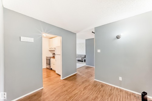 Interior hallway featuring wood-finish flooring and light gray walls - 423 5125 Riverbend Road, Edmonton, AB - Indoor Photo Showing Other Room