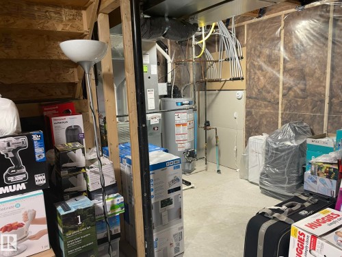 Utility area featuring a water heater, furnace, and exposed insulation - 871 Ebbers Crescent, Edmonton, AB - Indoor Photo Showing Basement