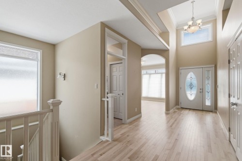 Entryway featuring a two-story ceiling, light wood-finish flooring, and a decorative frosted glass front door - 30 Valleyview Ridge, Fort Saskatchewan, AB - Indoor Photo Showing Other Room