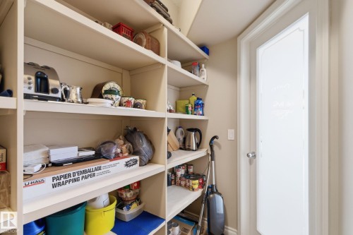 Built-in shelving storage featuring multiple levels, light-colored painted wood, and a frosted glass door - 30 Valleyview Ridge, Fort Saskatchewan, AB - Indoor With Storage