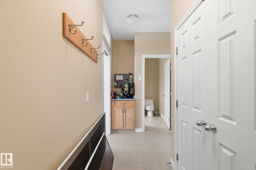 Hallway with light beige walls, panel doors, and a built-in light wood storage cabinet - 30 Valleyview Ridge, Fort Saskatchewan, AB - Indoor Photo Showing Other Room