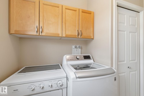 Dedicated laundry area featuring light wood-finish cabinetry with brushed nickel hardware and a bi-fold door - 30 Valleyview Ridge, Fort Saskatchewan, AB - Indoor Photo Showing Laundry Room