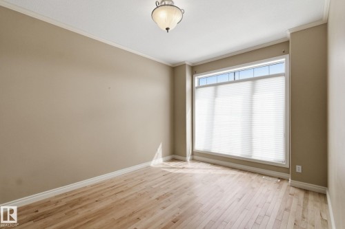 Spacious room featuring wood-finish flooring, neutral-toned walls, and white baseboards - 30 Valleyview Ridge, Fort Saskatchewan, AB - Indoor Photo Showing Other Room