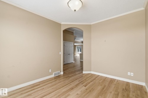 Spacious room featuring wood-finish flooring, neutral wall paint, white baseboards, and crown molding - 30 Valleyview Ridge, Fort Saskatchewan, AB - Indoor Photo Showing Other Room