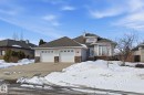 Two-car garage with white paneled doors, stone accents, and light-colored siding - 30 Valleyview Ridge, Fort Saskatchewan, AB  - Outdoor With Facade 