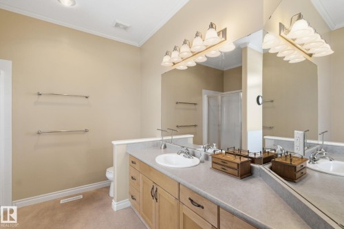 Bathroom featuring a double vanity with light wood cabinetry, white oval sinks, and chrome faucets - 30 Valleyview Ridge, Fort Saskatchewan, AB - Indoor Photo Showing Bathroom