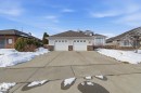 Split-level residence featuring a two-car garage with panel doors, stone veneer accents, and bay windows - 30 Valleyview Ridge, Fort Saskatchewan, AB  - Outdoor With Facade 