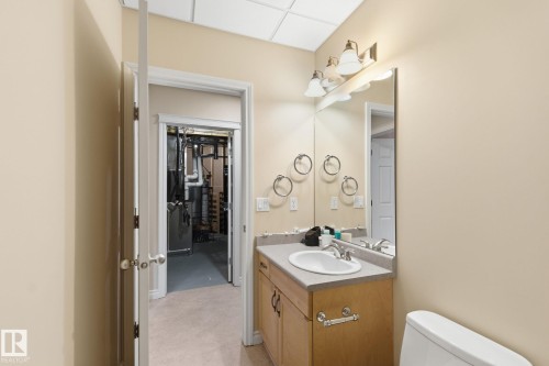 Bathroom vanity featuring a single basin sink, laminate countertop, and wood-finish cabinetry - 30 Valleyview Ridge, Fort Saskatchewan, AB - Indoor Photo Showing Bathroom