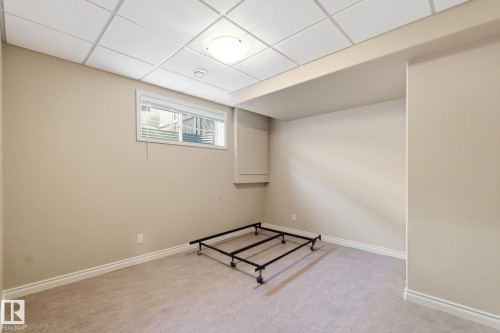 Neutral-toned bedroom featuring a drop ceiling with recessed lighting, an egress window with blinds, and light-colored carpeting - 30 Valleyview Ridge, Fort Saskatchewan, AB - Indoor Photo Showing Other Room