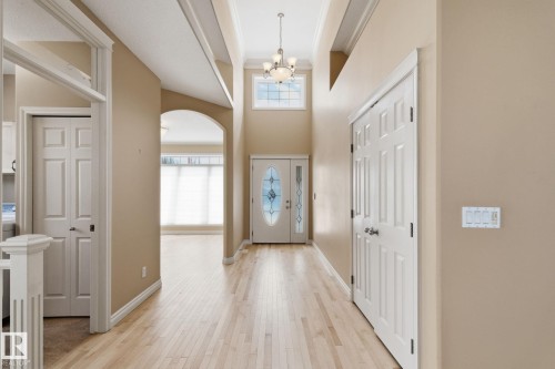 Grand entryway featuring light wood-finish flooring, a double front door with decorative glass inserts, and a transom window above - 30 Valleyview Ridge, Fort Saskatchewan, AB - Indoor Photo Showing Other Room