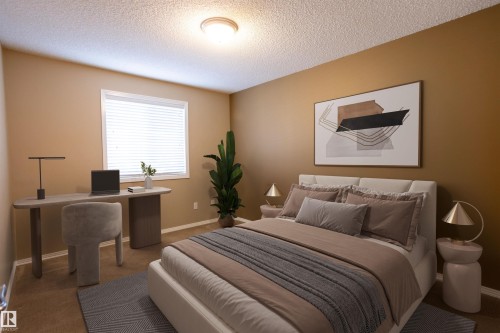 Bedroom featuring a window with blinds, a built-in light fixture, and warm-toned walls - 101 2420 108 Street, Edmonton, AB - Indoor Photo Showing Bedroom