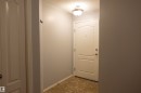 Entryway featuring a paneled door, flush-mount ceiling light fixture, neutral wall paint, and patterned floor tile - 101 2420 108 Street, Edmonton, AB  - Indoor Photo Showing Other Room 