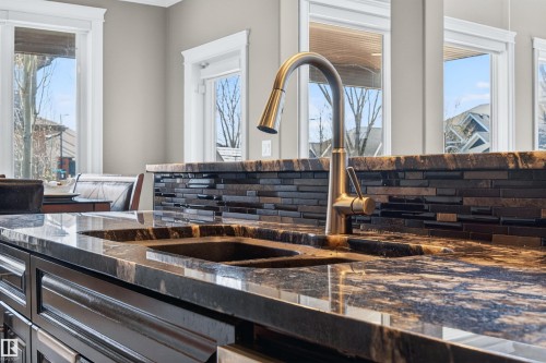 Dual undermount sinks with a high-arc faucet set into a polished countertop - 1254 Adamson Drive, Edmonton, AB - Indoor